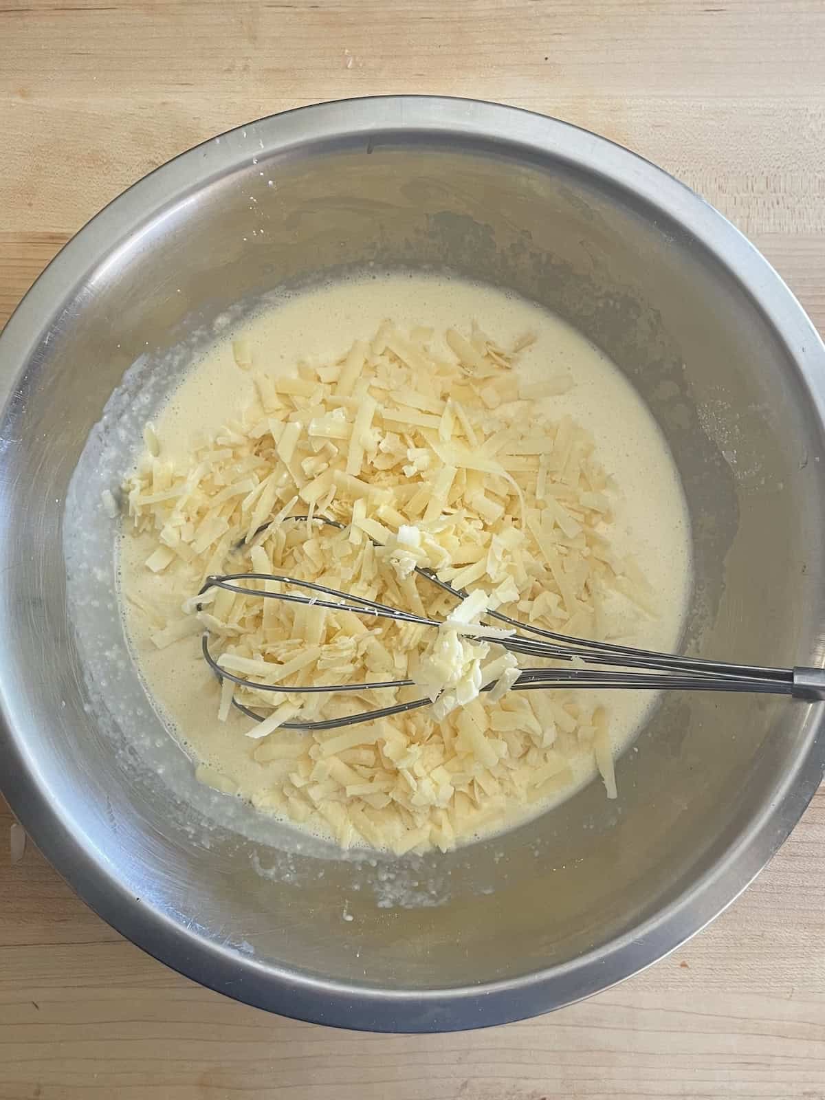 Corn Bread Pudding mixing custard in a bowl
