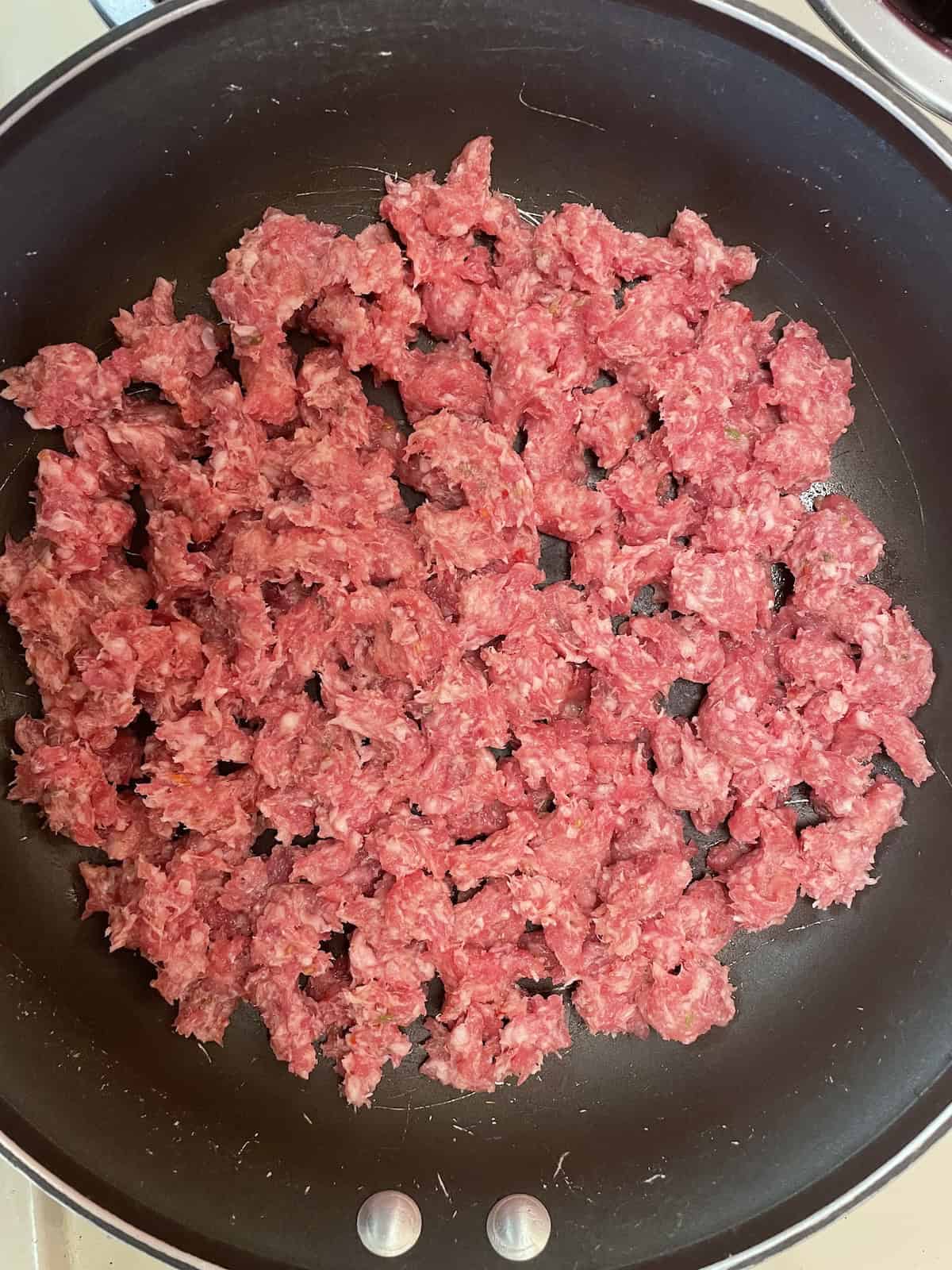 uncooked sausage in skillet