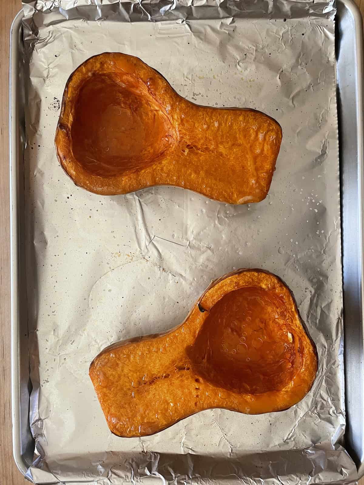 roasted butternut squash on baking sheet being removed from the oven