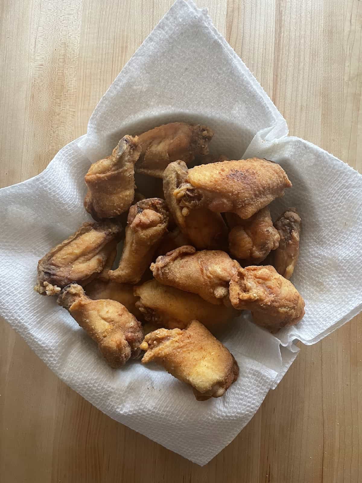 Polynesian Chicken Wings with Pineapple Mustard Sauce -- fried wings draining