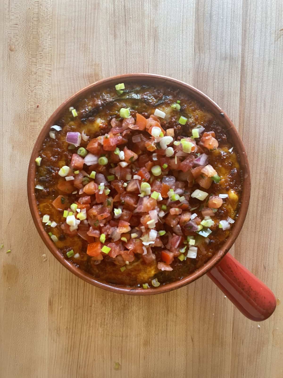 Queso Fundido with Chorizo garnished with pico de Gallo and scallions