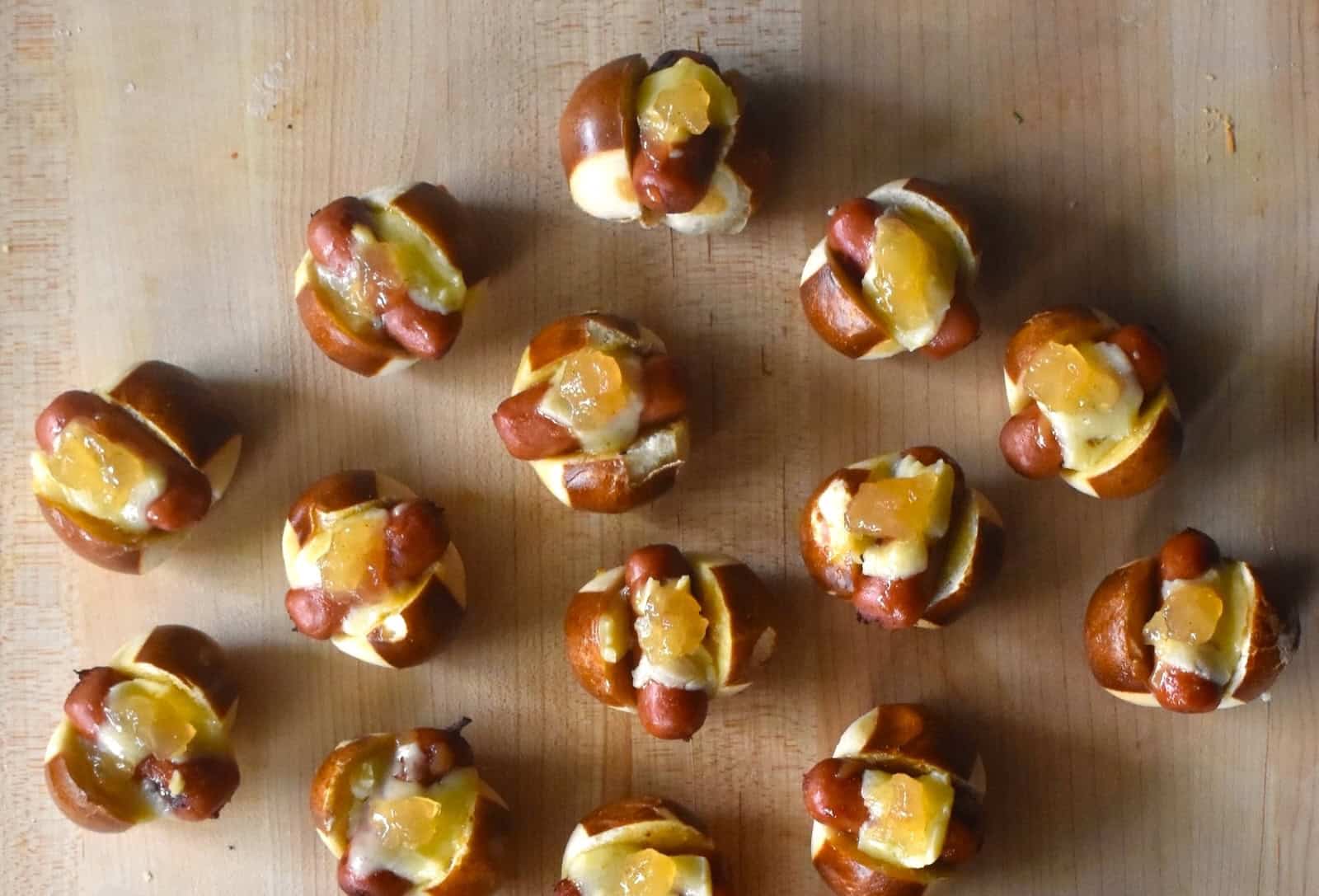 Little Smokie Pretzel Bites with Honey Mustard and Apple Jelly on a serving board