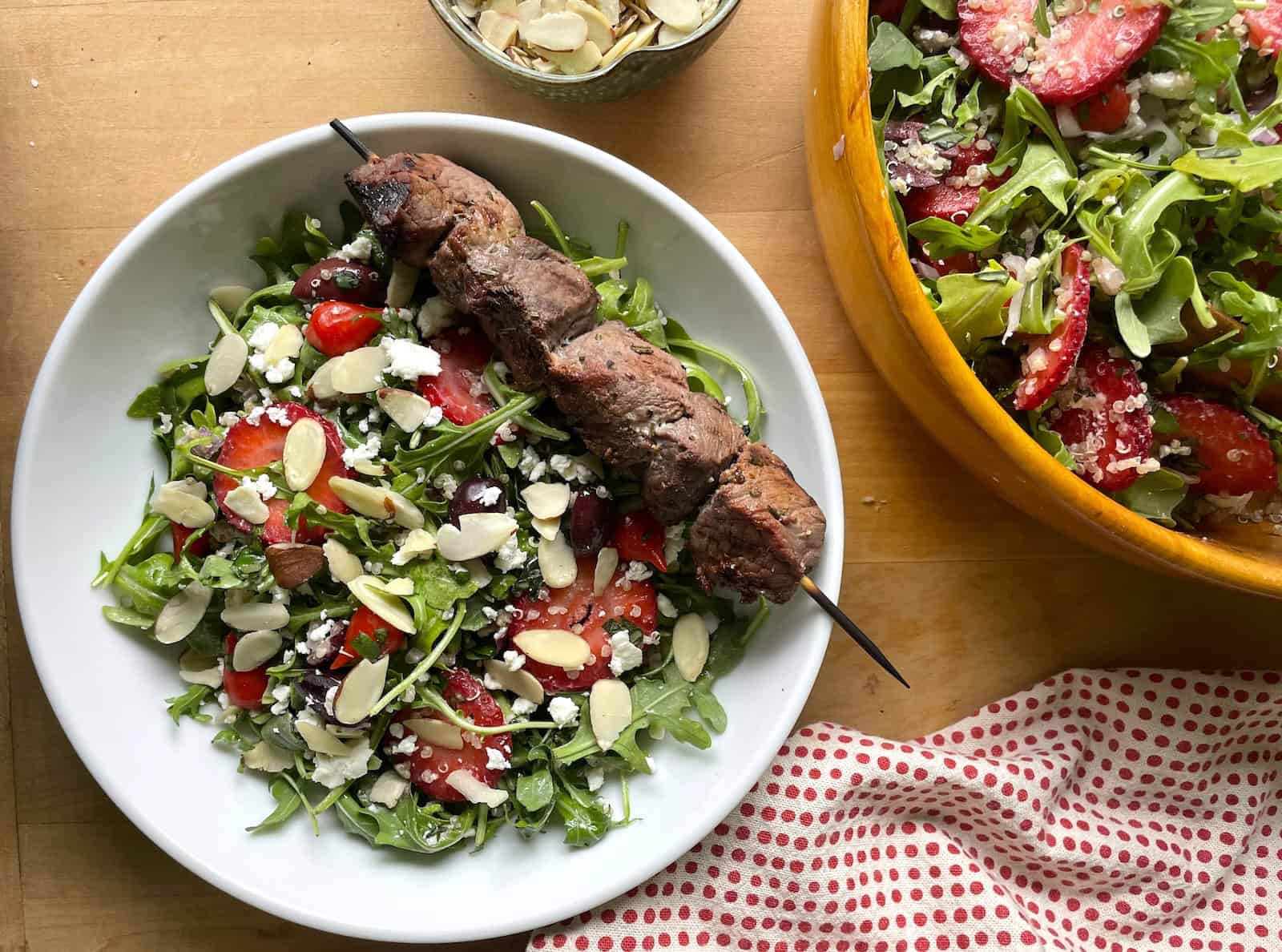 Arugula, Strawberry and Quinoa Salad with Rosemary Steak Tip Kebabs overhead photo