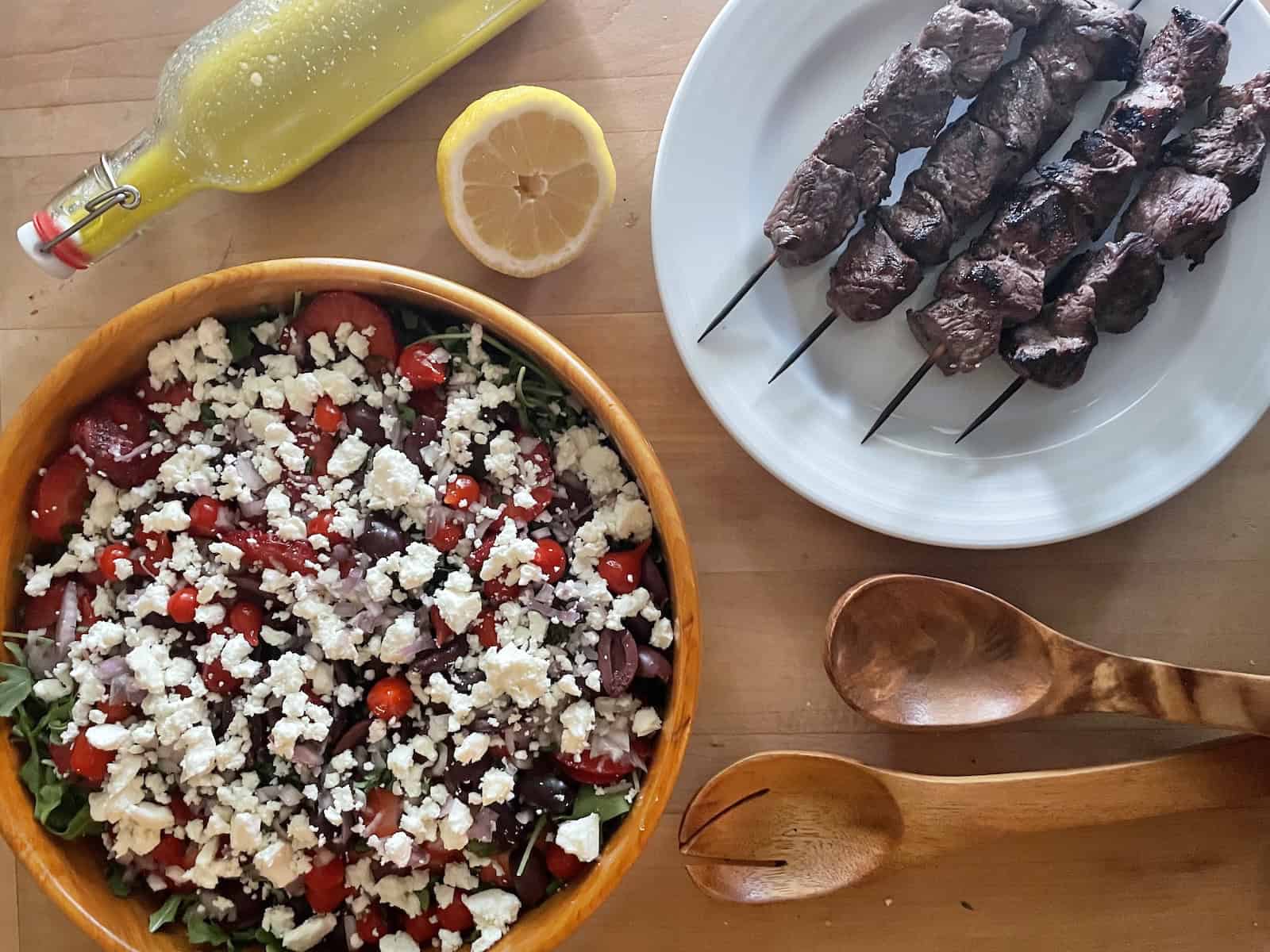 Arugula, Strawberry and Quinoa Salad with Rosemary Steak Tip Kebabs ready to serve