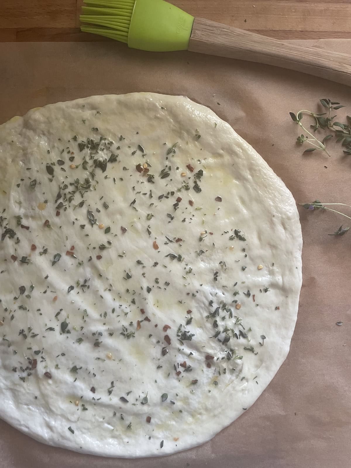 pizza crust sprinkled with thyme and red pepper flakes