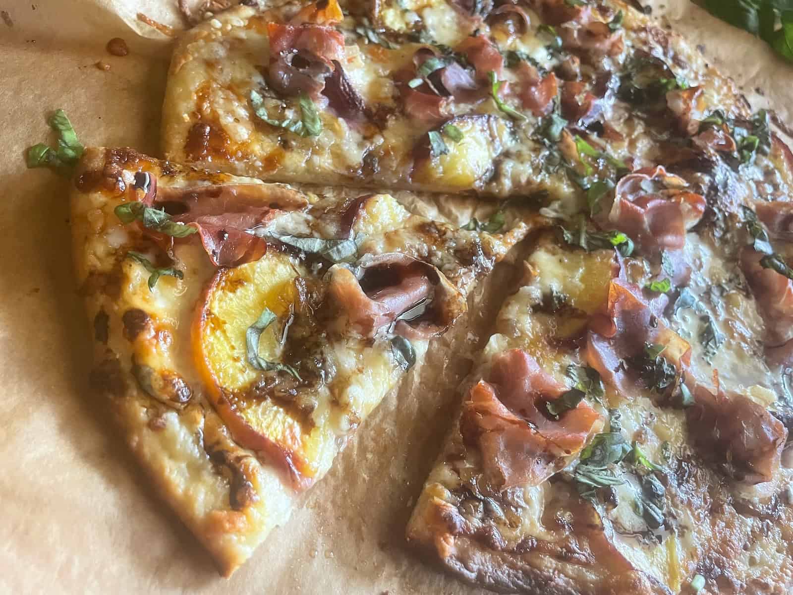 Peach and prosciutto pizza slice
