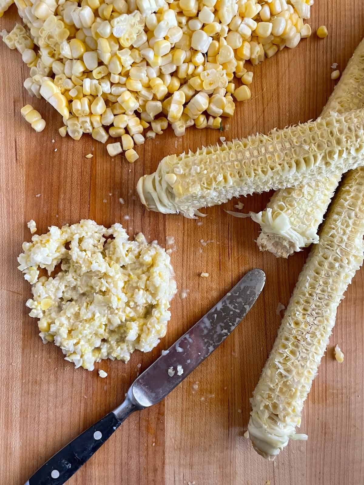 scraping corn from corn cobs
