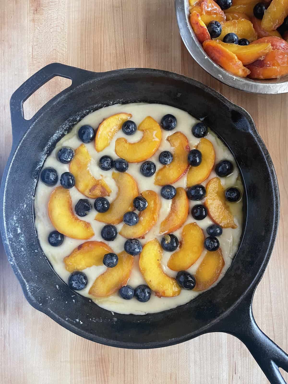 adding the first layer of fruit to batter