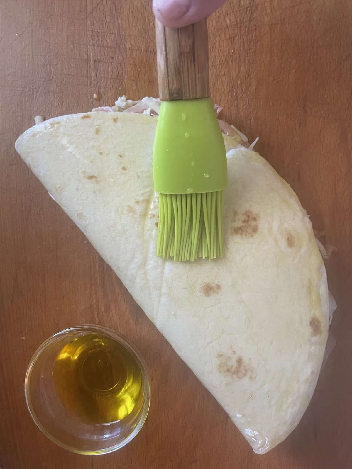 brushing tortilla with olive oil