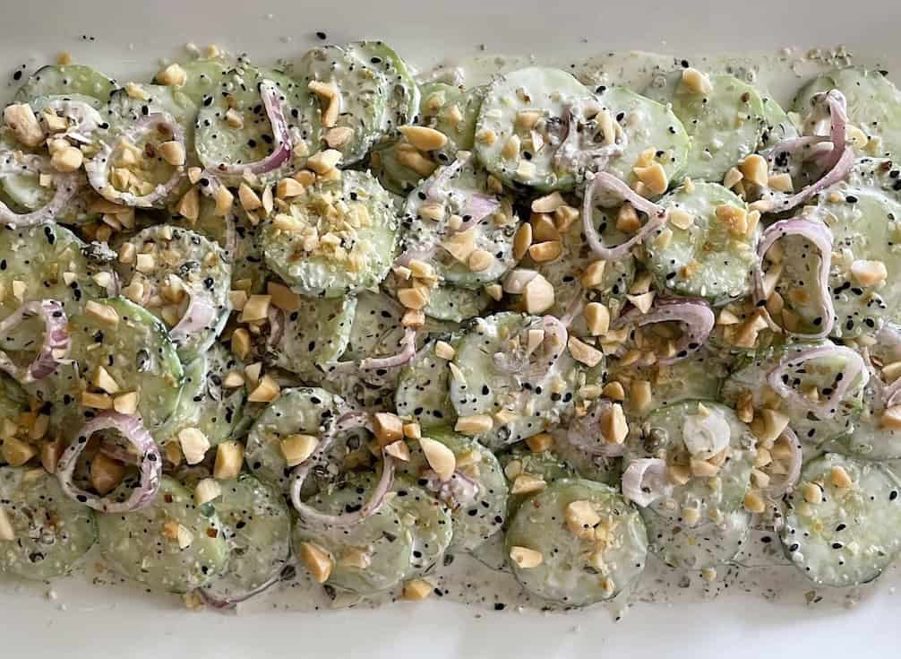 Buttermilk Cucumbers with Almonds and Everything Close-up on platter