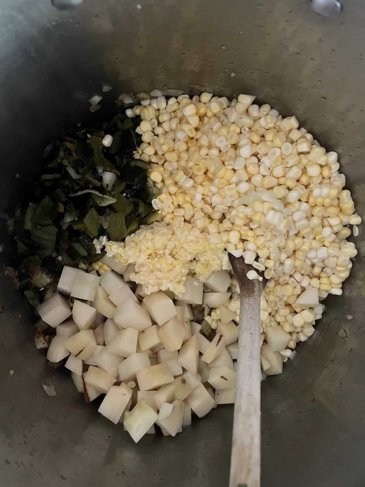 adding corn, poblanos and potato to the pot