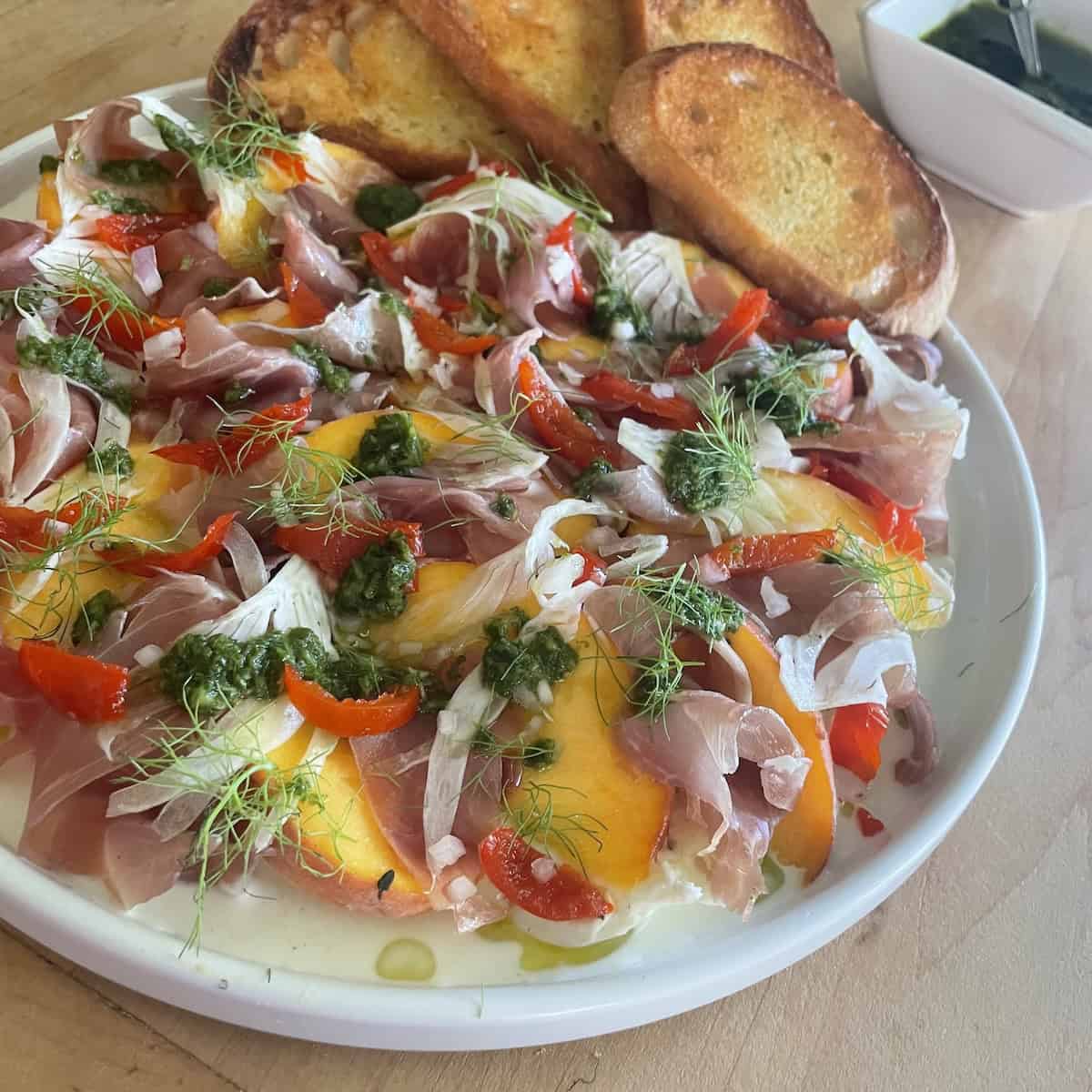 Peach Bruschetta with Burrata, Prosciutto and Arugula Oil