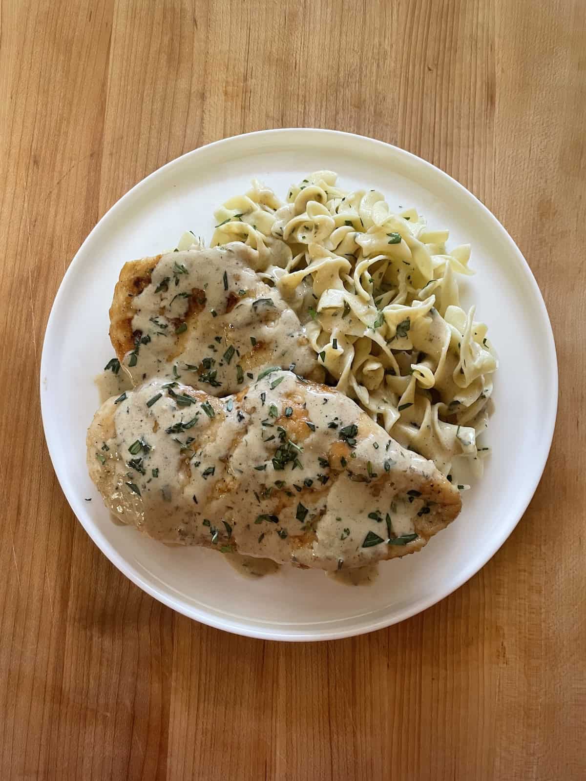 Chicken with Mustard and Tarragon Cream on a plate with buttered noodles