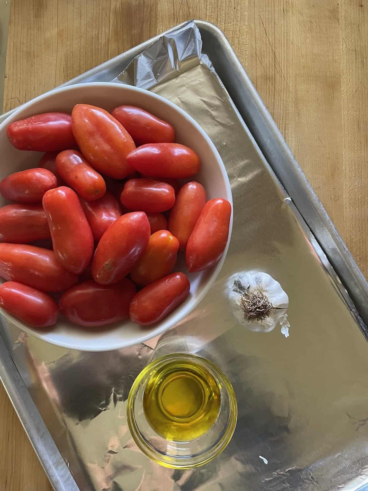 tomatos and olive oil on a baking sheet