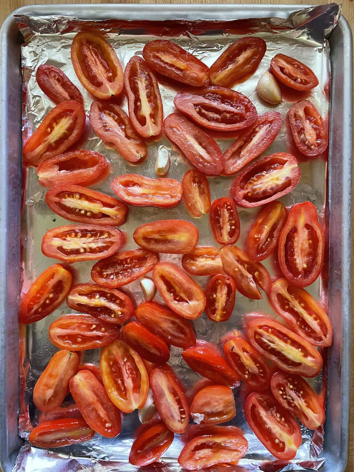 tomatoes cut in half on baking sheet