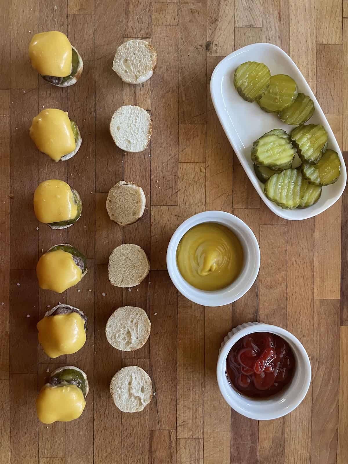 topping the pickle with a mini cheeseburger