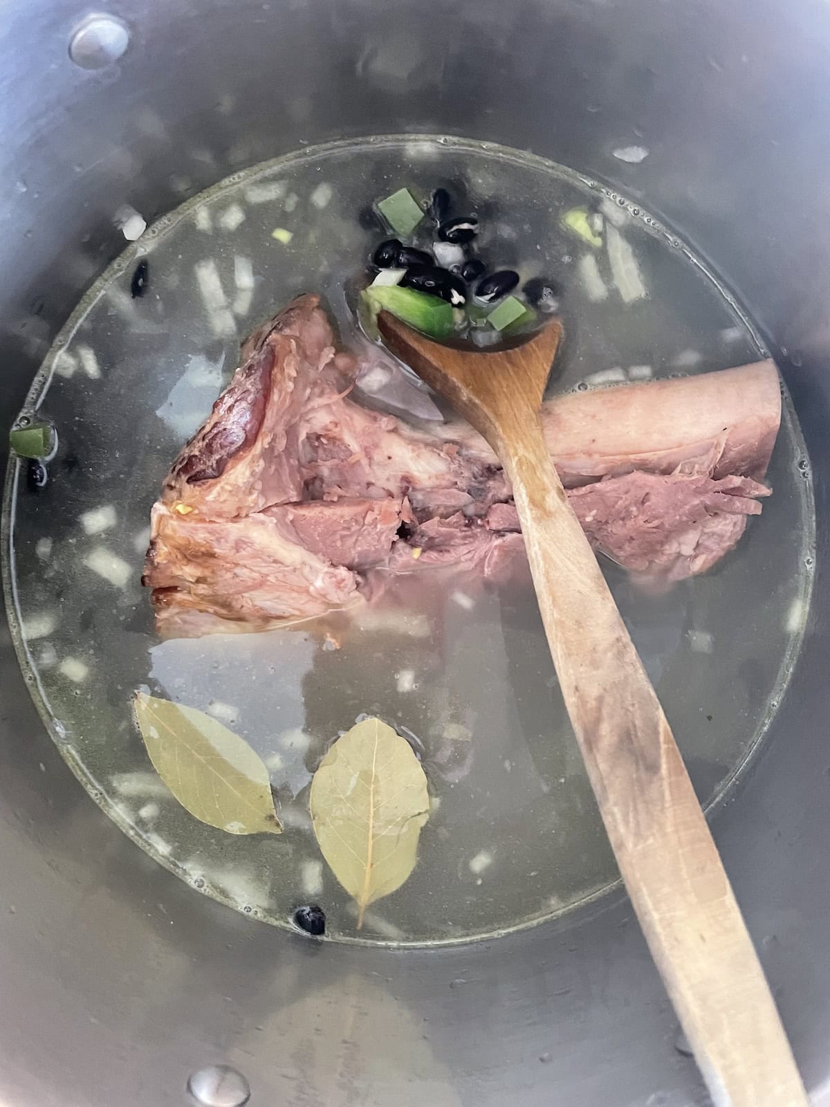 add broth, hambone and bay leaf to beans