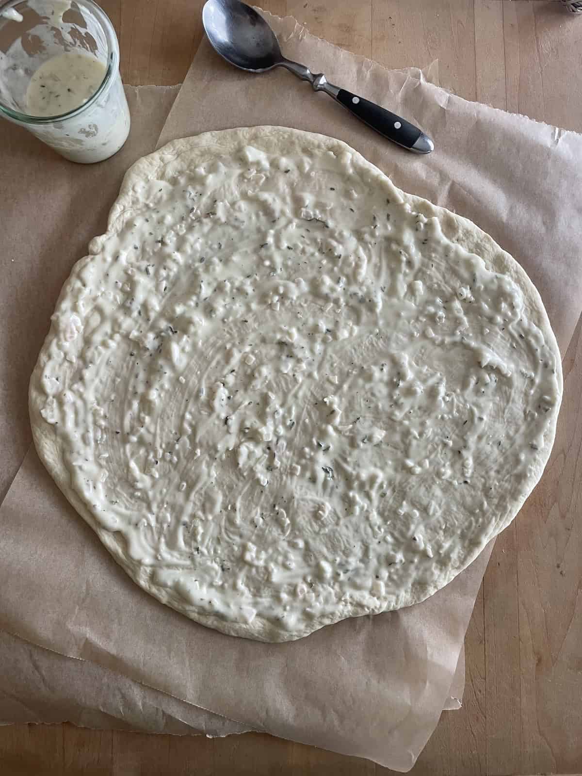 spread white pizza sauce over top of crust