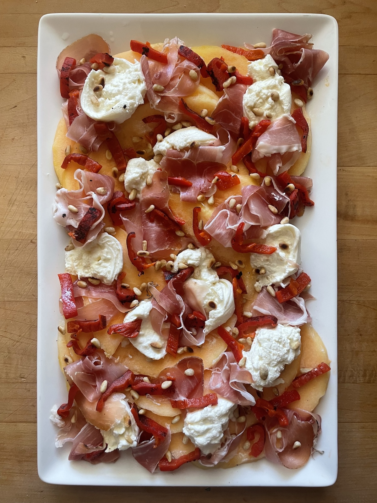top with roasted red peppers and pine nuts
