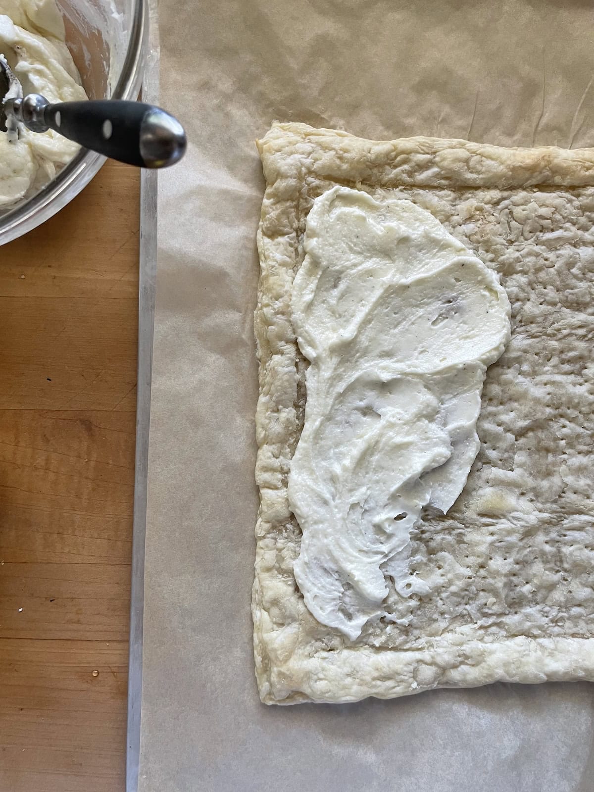 spreading mascarpone on partially baked puff pastry